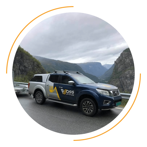 Bil og henger som står parkert. Logo med vossliftutleie